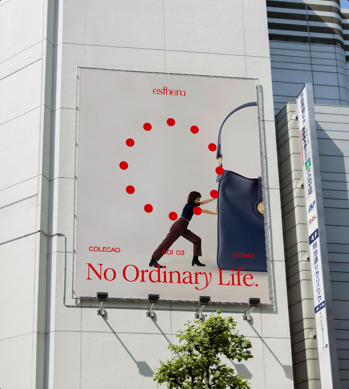 Building billboard for esthera: a woman pushes a giant navy handbag under the line "No Ordinary Life."