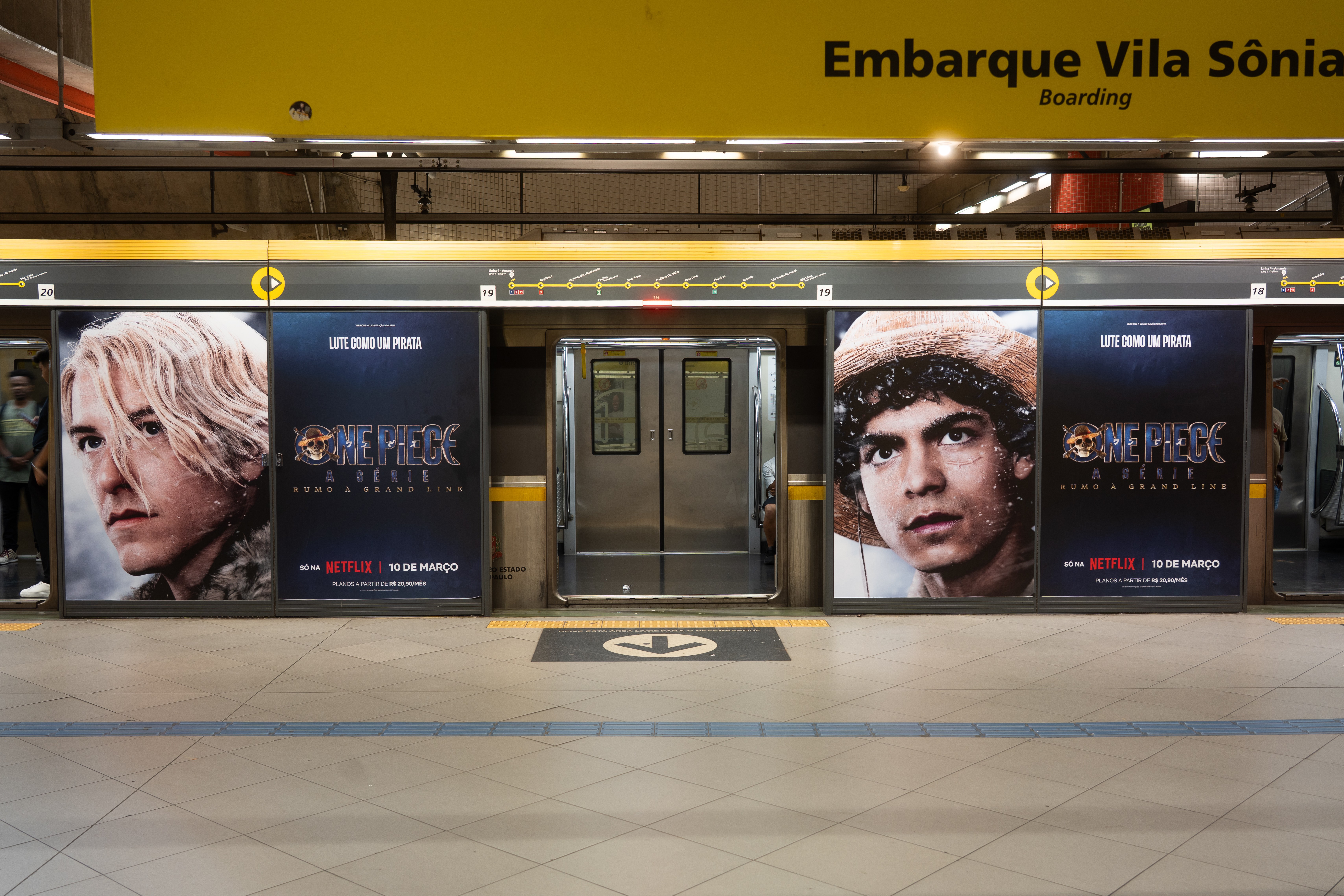One Piece character posters wrap the platform screen doors at a metro station signed "Embarque Vila Sônia"